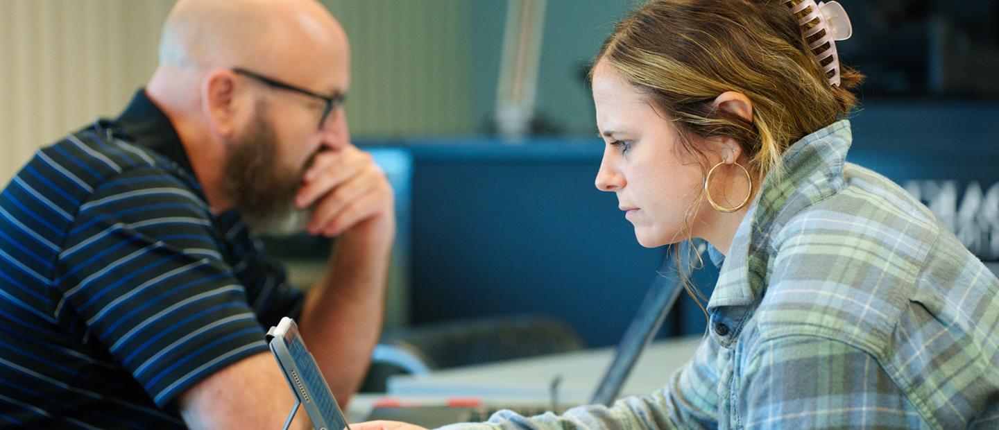 Two adult learners working on laptops